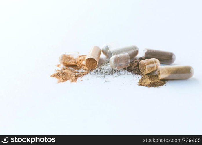 Herbal pills. Open Herbal Medicines capsules and powder on white background.. Herbal pills. Open Herbal capsules and powder on white background.