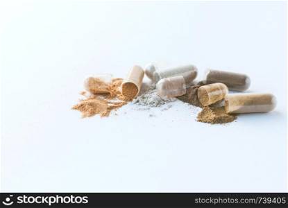 Herbal pills. Open Herbal Medicines capsules and powder on white background.. Herbal pills. Open Herbal capsules and powder on white background.