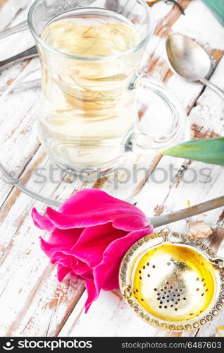 Herbal tea and spring tulip. Cup with fragrant tea and spring pink tulips
