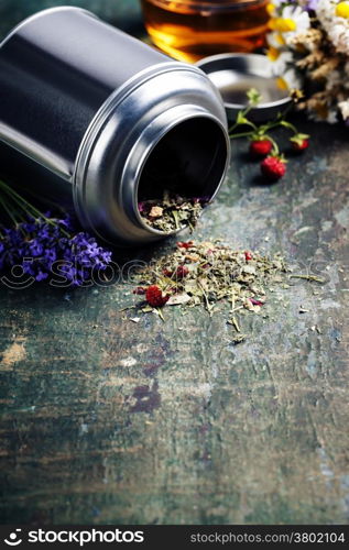 Herbal tea and wild organic flowers on wooden background