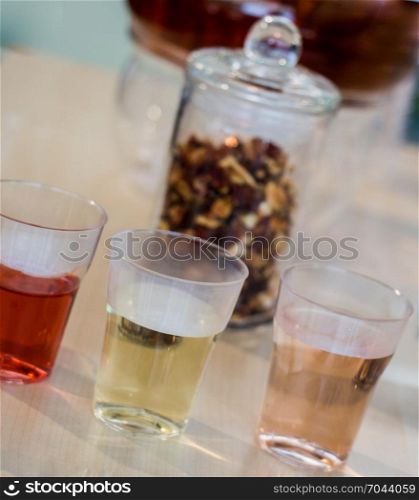 Herbal tea brewed in glass teapot and tea plant in in glasses