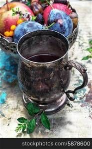 Herbal tea . Herbal tea in iron stylish mug for medicinal herbs with fruit