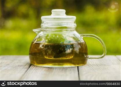 Herbal tea in a glass teapot on the table outdoor