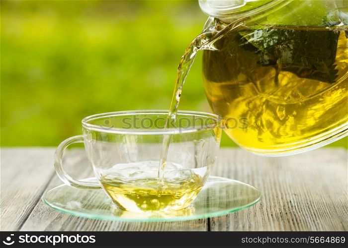 Herbal tea in a glass teapot on the table outdoor