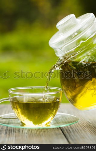 Herbal tea in a glass teapot on the table outdoor. The Herbal tea