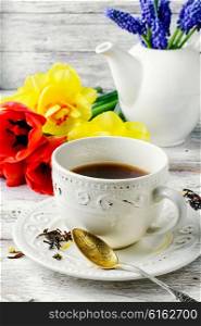 Herbal tea in a stylish mug and bouquet of tulips. tea and flowers