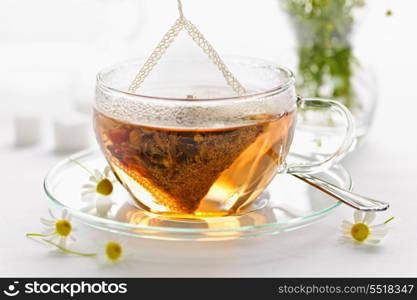 Herbal tea in glass cup. Glass teacup with soothing herbal tea in silk bag