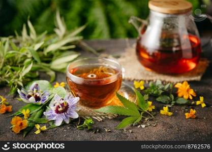 Herbal tea passion flower  passiflora  and hemp leaves on rustic background. Soothing natural remedy. CBD cannabioids in small amounts are healthy for physical and mental health. Herbal tea from the leaves of the passion flower