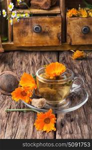 Herbal tea with calendula. Glass cup with herbal medicinal tea from marigold petals