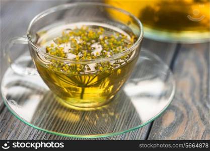 Herbal tea with dill in a glass cup outdoors