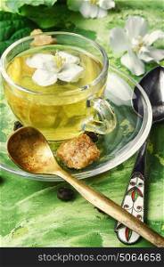 herbal tea with Jasmine flowers. glass of herbal tea with the aroma of Jasmine flower on green background