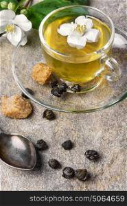 herbal tea with Jasmine flowers. glass of herbal tea with the aroma of Jasmine flower on stone background
