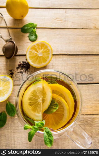 Herbal tea with lemon and mint on a wooden background. Delicious drink for relaxation and alternative therapy of diseases.. Herbal tea with lemon and mint on wooden background. Delicious drink for relaxation and alternative therapy of diseases.