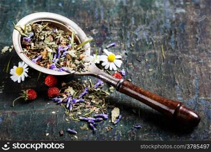 Herbal tea with wild flowers and berry on wooden background - bio food, health and diet concept