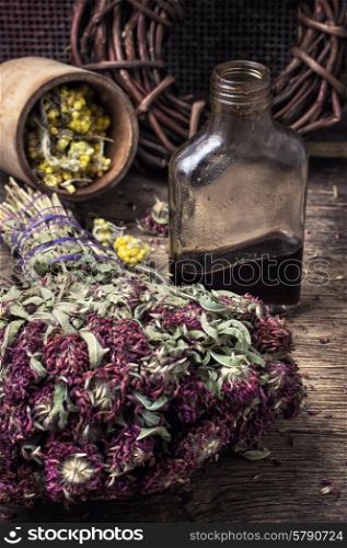 Herbs and glass bulb with decoction of them in rustic style