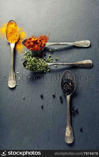 Herbs and spices selection - herbs and spices, old metal spoons and slate background - cooking, healthy eating