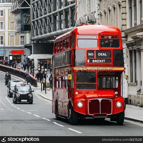 Heritage Routemaster Bus operating in a busy Central London street with traditional black cab on background. Written No Deal Brexit as destination in mock-up to the Leave the EU campaign. No deal Brexit Routemaster London Bus with black cab