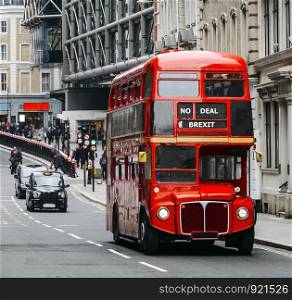 Heritage Routemaster Bus operating in a busy Central London street with traditional black cab on background. Written No Deal Brexit as destination in mock-up to the Leave the EU campaign. No deal Brexit Routemaster London Bus with black cab