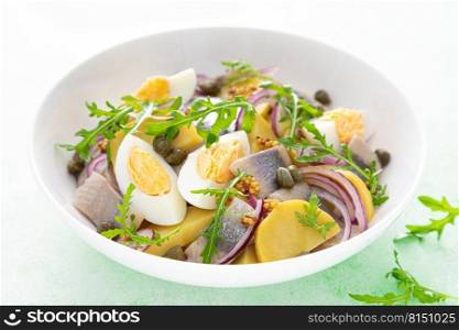 Herring and boiled potato salad with egg, capers and red onion