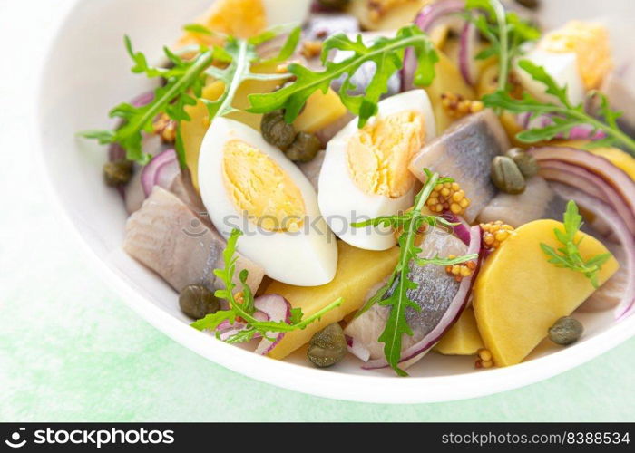 Herring and boiled potato salad with egg, capers and red onion