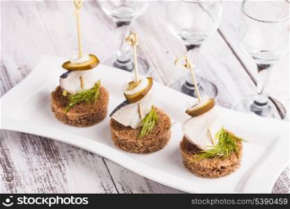 Herring canape with onion, pickled cucumber and dill