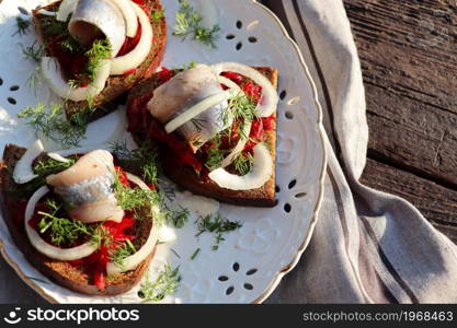 Herring fillet. Scandinavian cuisine. sandwich with slices of pickled Atlantic herring fillet, beetroot salad, onion and microgreen.