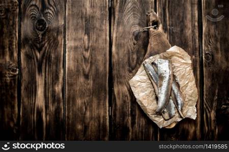 Herring on old paper. On a wooden table.. Herring on old paper