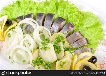 Herring with potato and fresh vegetables closeup
