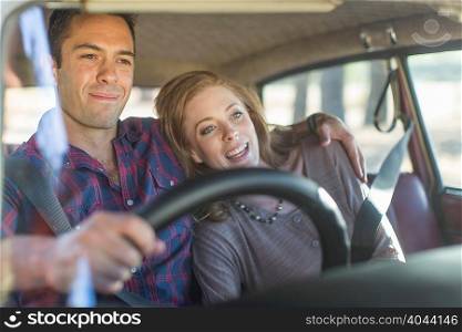 Heterosexual couple in car together, smiling