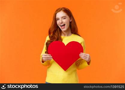 Hey gorgeous you have my heart. Valentines day, boyfriend and girlfriend concept. Cute and sassy redhead woman holding large sign and smiling, wink coquettish, standing orange background.. Hey gorgeous you have my heart. Valentines day, boyfriend and girlfriend concept. Cute and sassy redhead woman holding large sign and smiling, wink coquettish, standing orange background