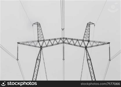 Hi-voltage electric power lines in a wintry foggy landscape, black and white photo. Hi-voltage electric power lines in a wintry foggy landscape, black and white photo.