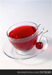 hibiscus herbal tea in glass cup with ripe tasty cherry