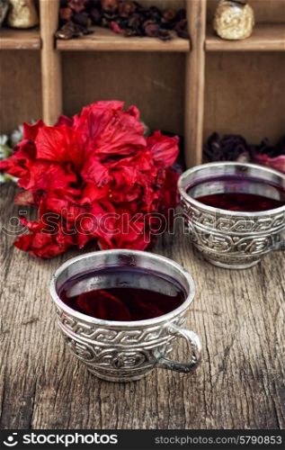 Hibiscus tea. Hibiscus tea rose and welding on the background of the tea shelves in vintage style.Photo tinted