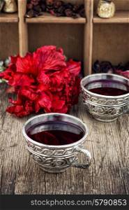 Hibiscus tea. Hibiscus tea rose and welding on the background of the tea shelves in vintage style.Photo tinted
