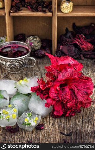 Hibiscus tea rose and welding on the background of the tea shelves