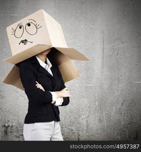 Hiding emotions. Businesswoman in suit wearing carton box on head