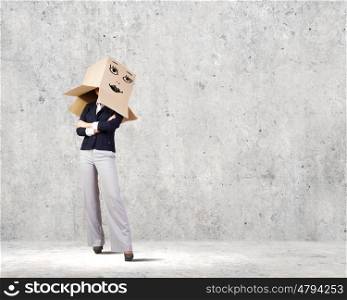 Hiding face. Confident businesswoman wearing carton box on head