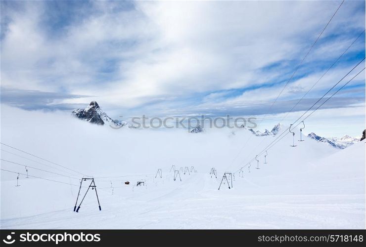 High altitude slopes and ski-lifts in Zermatt ski area. In background the Matterhorn and others peaks in Valais canton, Switzerland, European Alps.