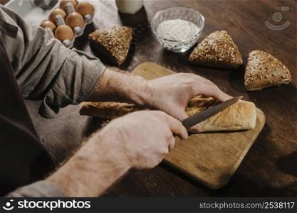 high angle chef cutting bread