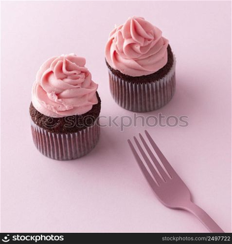 high angle cupcakes with pink icing fork