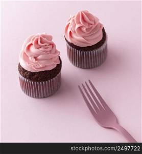 high angle cupcakes with pink icing fork