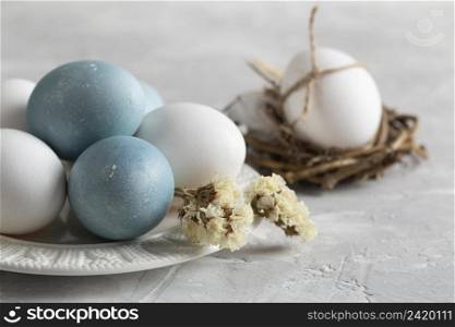 high angle easter eggs bird nest with plate flowers
