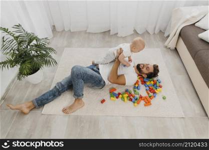 high angle father playing floor home with baby