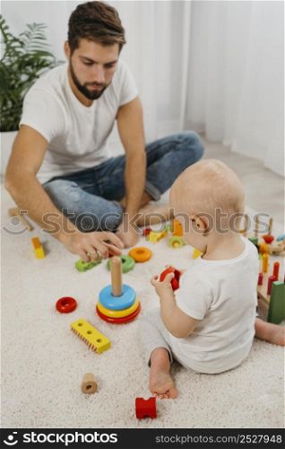 high angle father playing with baby home