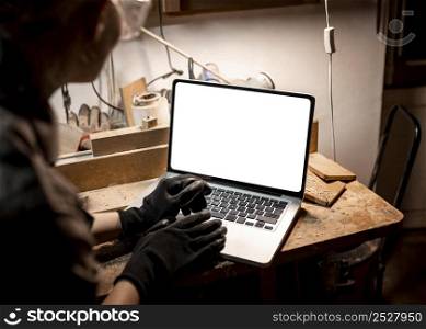 high angle female carpenter using laptop