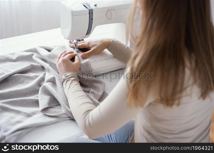 high angle female tailor with sewing machine fabric. High resolution photo. high angle female tailor with sewing machine fabric. High quality photo