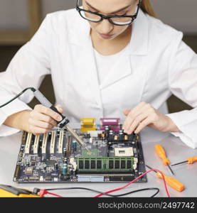 high angle female technician with electronics soldering iron