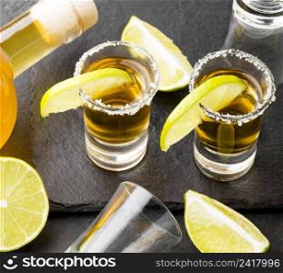 high angle gold tequila shots lime with salt bottle
