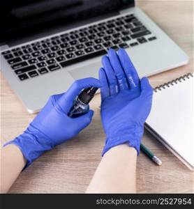 high angle hands with surgical gloves using hand sanitizer