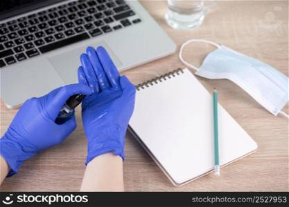 high angle hands with surgical gloves using hand sanitizer desk